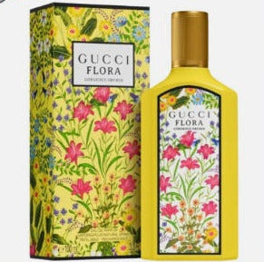 Gucci Flora Eau de Toilette bottle and matching floral-patterned box, shown on a white background with a red border and a small US flag badge in the top-left corner.