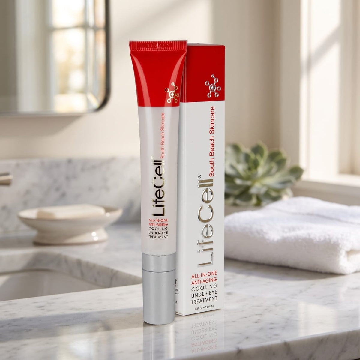 LifeCell Cooling Under Eye Treatment shown as a red and white squeeze tube next to its matching retail box on a marble countertop in a bright bathroom setting.