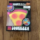 A novelty plastic squeeze pizza slice toy in its original retail packaging, displayed on a wooden surface.